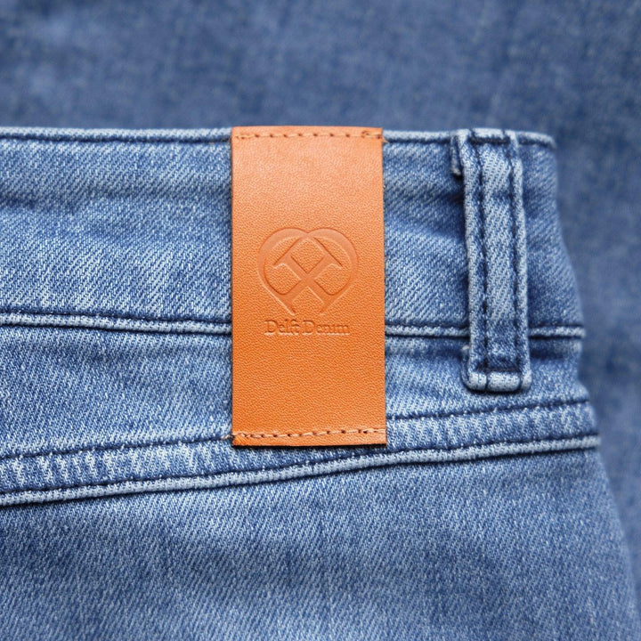 Detail van een Delft Denim dames spijkerbroek – close-up van de leren patch met logo. Duurzame denim van biologisch en gerecycled katoen met premium afwerking.