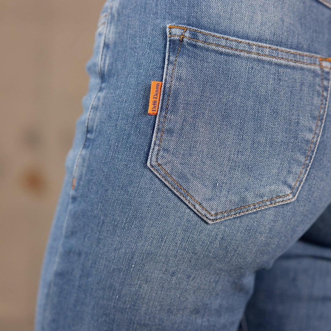 Zijaanzicht van een model in The Skinny jeans van Delft Denim – close-up van de achterzak met oranje merklabel. Duurzame dames spijkerbroek van biologisch en gerecycled katoen.