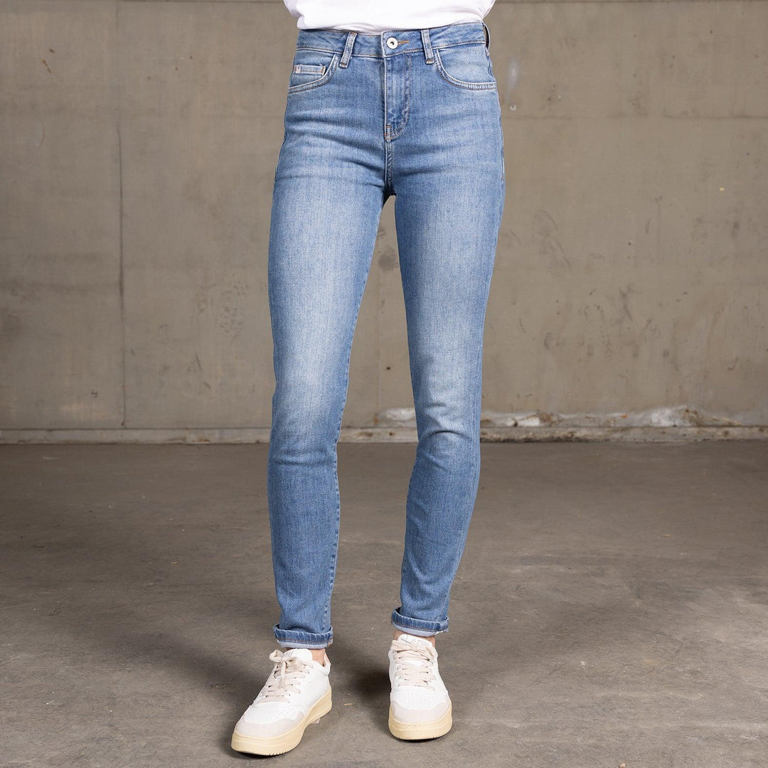 Vooraanzicht van een model in The Skinny jeans van Delft Denim – een high-waist skinny fit jeans met lichte wassing, duurzame denim en een flatterende pasvorm.