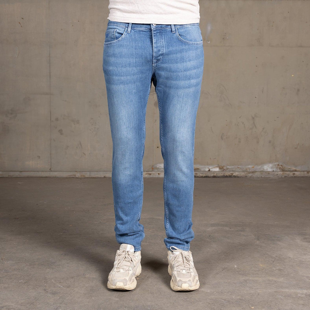 Vooraanzicht van een model in The Slim jeans van Delft Denim – een duurzame slim-fit heren spijkerbroek. Gemaakt van biologisch en gerecycled katoen voor een moderne pasvorm.